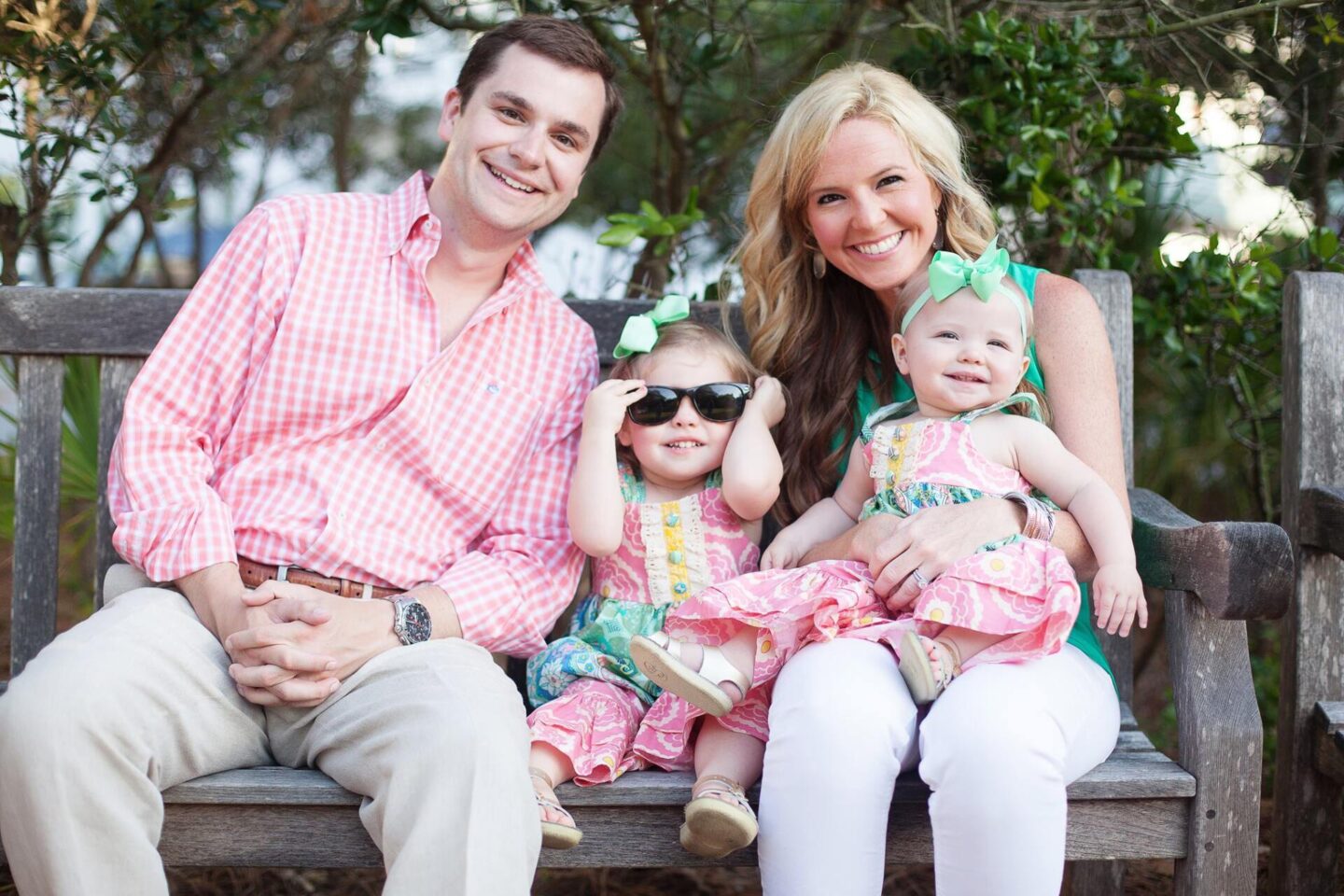 10 Year Wedding Anniversary by popular Nashville lifestyle blog, Hello Happiness: image of a mom and dad and their two young daughters sitting on a wooden bench. 