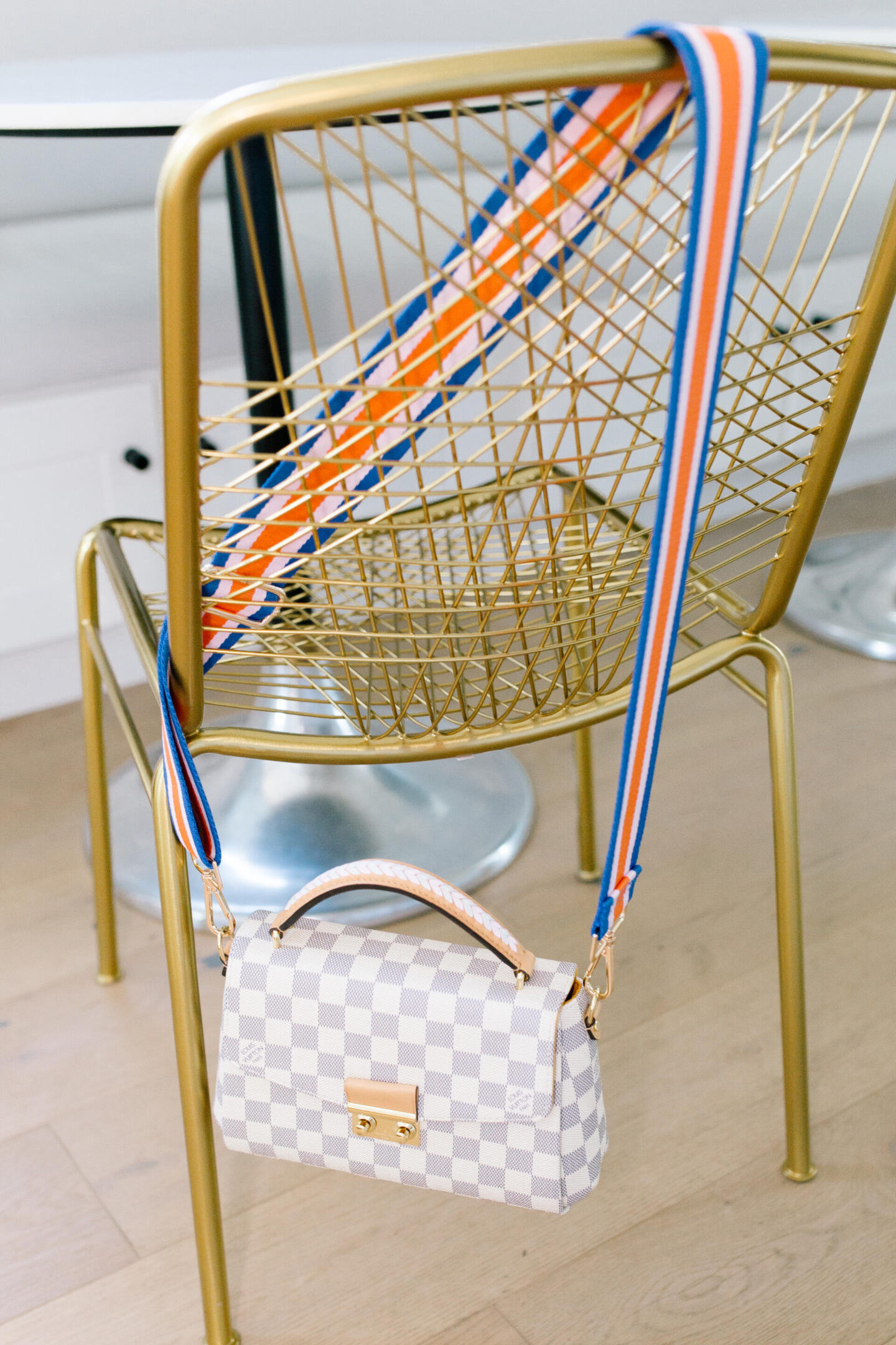 Bag Straps by popular Nashville fashion blog, Hello Happiness:image of a bag with a Social Threads bag strap hanging form a gold metal chair. 