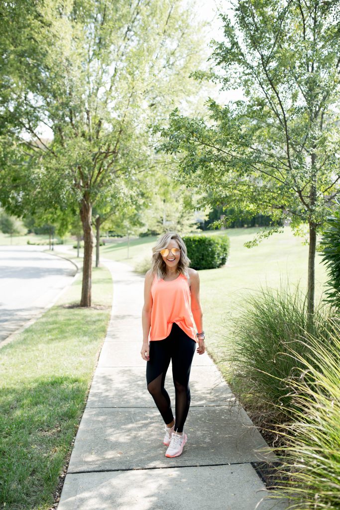 Working on my Fitness...Under Armour Fashion Style by popular Nashville fashion blog, Hello Happiness: image of a woman outside wearing Under Armour HeatGear® Armour Mesh Graphic Ankle Crop, Under Armour® Mid Crossback, Under Armour UA Whisperlight Tie Back Women’s Tank Top, and Under Armour UA HOVR™ Infinite Mojave women's running shoes.