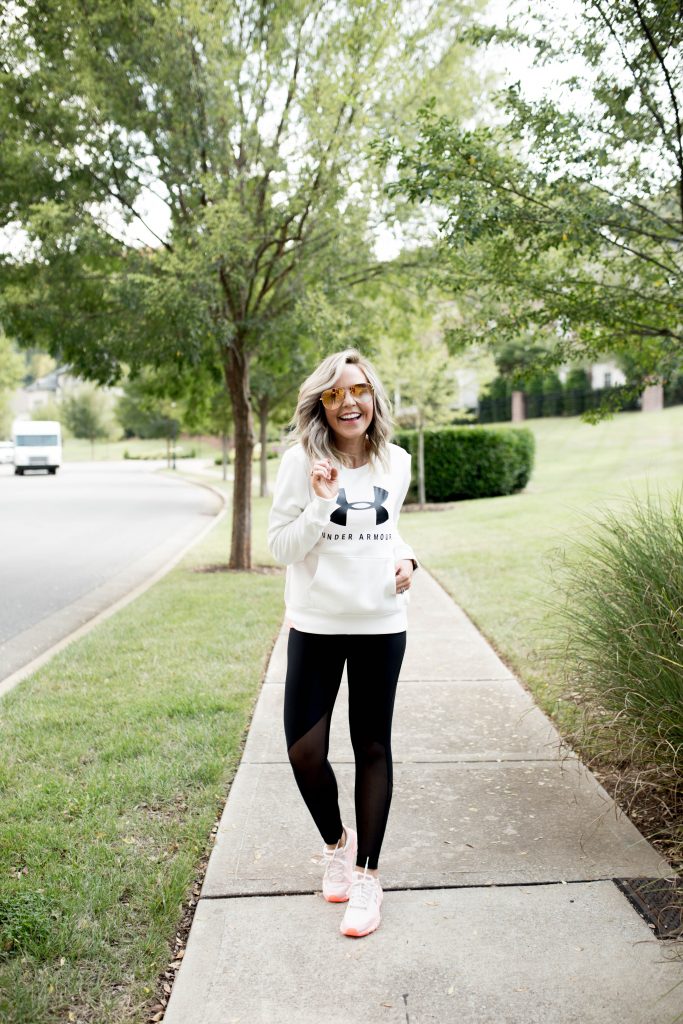 Working on my Fitness...Under Armour Fashion Style by popular Nashville fashion blog, Hello Happiness: image of a woman outside wearing Under Armour HeatGear® Armour Mesh Graphic Ankle Crop, Under Armour® Mid Crossback, Under Armour UA Favorite Fleece Sportstyle Graphic Crew, and Under Armour UA HOVR™ Infinite Mojave women's running shoes.