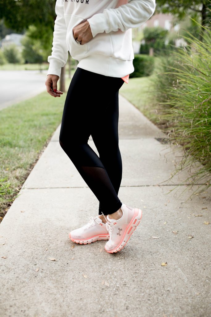 Working on my Fitness...Under Armour Fashion Style by popular Nashville fashion blog, Hello Happiness: image of a woman outside wearing Under Armour HeatGear® Armour Mesh Graphic Ankle Crop, Under Armour® Mid Crossback, Under Armour UA Favorite Fleece Sportstyle Graphic Crew, and Under Armour UA HOVR™ Infinite Mojave women's running shoes.