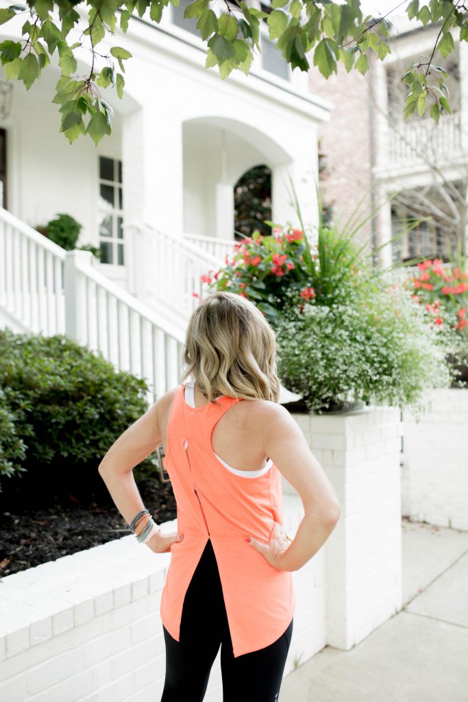 Working on my Fitness...Under Armour Fashion Style by popular Nashville fashion blog, Hello Happiness: image of a woman outside wearing Under Armour HeatGear® Armour Mesh Graphic Ankle Crop, Under Armour® Mid Crossback, Under Armour UA Whisperlight Tie Back Women’s Tank Top, and Under Armour UA HOVR™ Infinite Mojave women's running shoes.