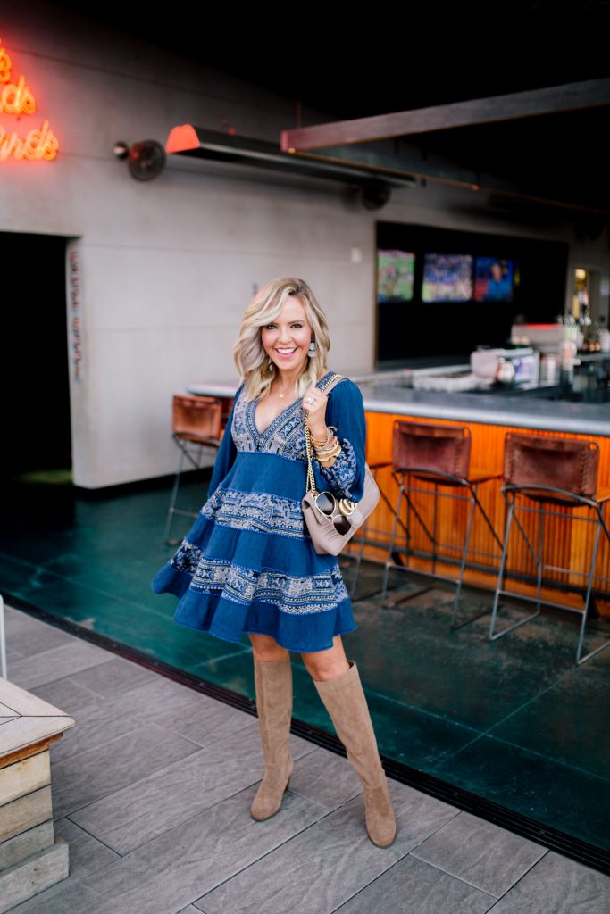 The New and Now at Noelle Nashville by popular Nashville blog, Hello Happiness: image of a woman at the Rarebird Rooftop Bar in the Noelle hotel in Nashville and wearing a Free People My Love Long Sleeve Minidress, Sole Society PRONY WEDGE BOOT, Nordstrom Gucci Medium GG Marmont 2.0 Matelassé Leather Shoulder Bag, and Able earrings. 