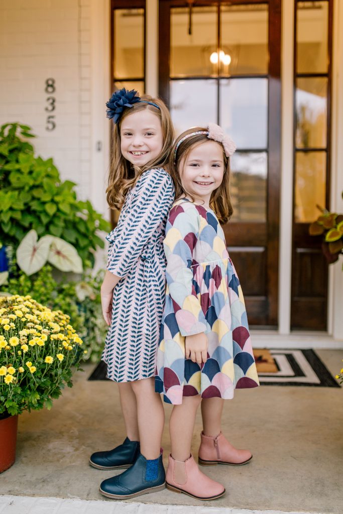The Friday Five...by popular Nashville life and style blog, Hello Happiness: image of a two little girls standing together outside and wearing The Frilly Frog CAROLINE DRESS - CRYSTAL ROSE LEAVES, Boden navy Leather Chelsea Boots, The Frilly Frog AMMA DRESS - MULTI MERMAID, and Target Cat and Jack Toddler Girls' Ashley Fashion Boots.