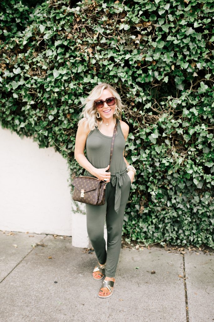 Ready, Set, SHOP! The Best in 4th of July Sales by popular Nashville fashion blog, Hello Happiness: image of woman standing outside in front of white brick wall covered in ivy and wearing Fitflop SCALLOP Leather Slides and a LOFT BEACH TERRY TIE WAIST JUMPSUIT.