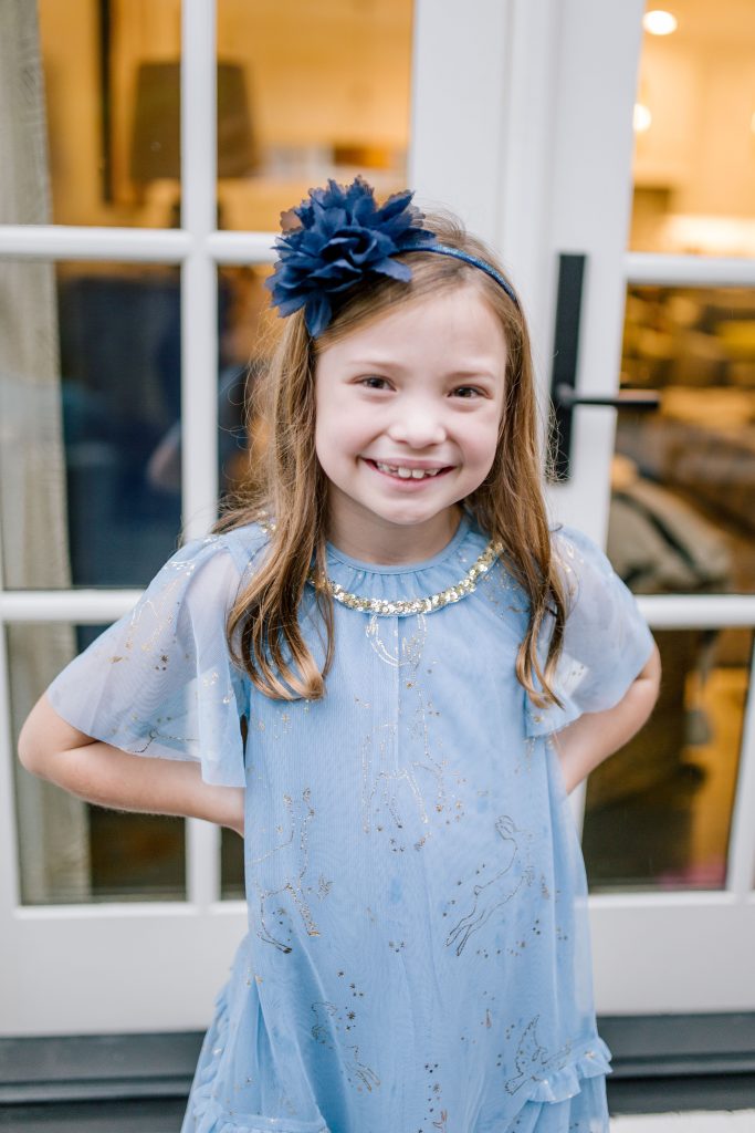 Party-Worthy Looks with the Boden Harry Potter Collection by popular Nashville fashion blog, Hello Happiness: image of a girl standing on some stairs and wearing a Boden Patronus Party Dress, Boden Party Twinkle Tights, and Boden Party Ballet Flats. 