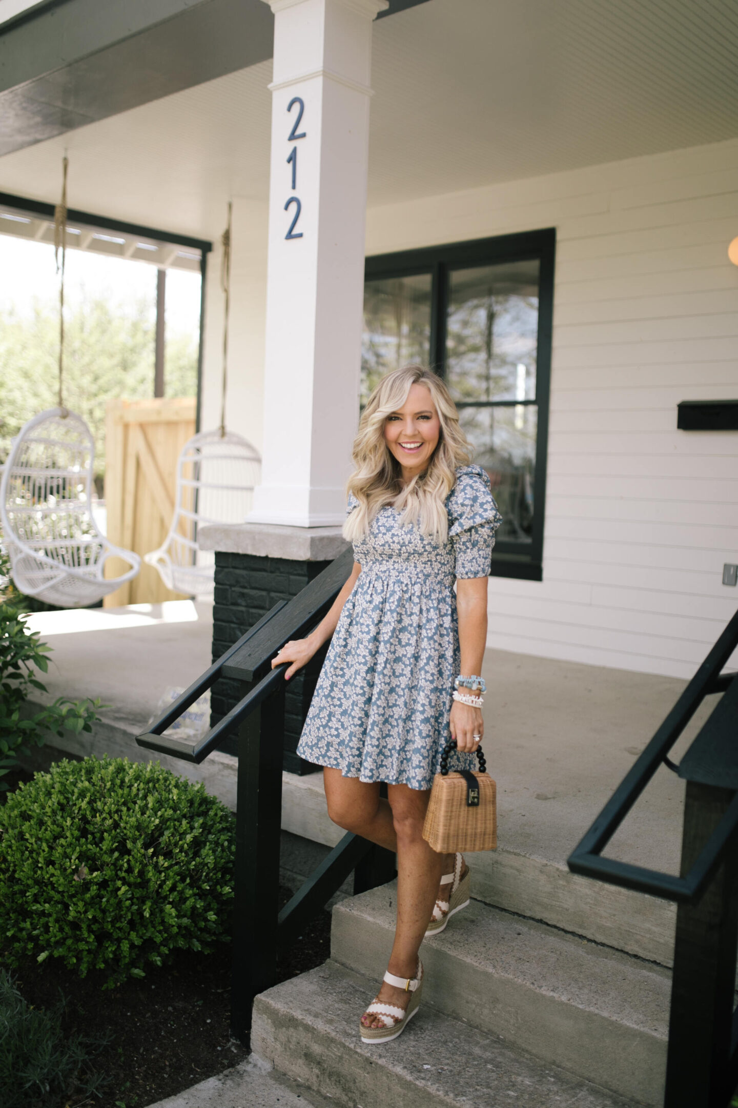Summer Dress by popular Nashville fashion blog, Hello Happiness: image of a woman standing on some cement stairs and wearing a pastoral dress, Glyn espadrilles, and holding a woven tote. 