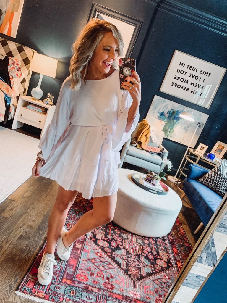 My Current Amazon Favorites by popular Nashville fashion blog, Hello Happiness: image of a woman standing in her room and wearing a PRETTYGARDEN Women’s Casual Solid Color O-Neck 3/4 Bell Sleeve Ruffle Swing A Line Mini Dress Sundress with Belt. 
