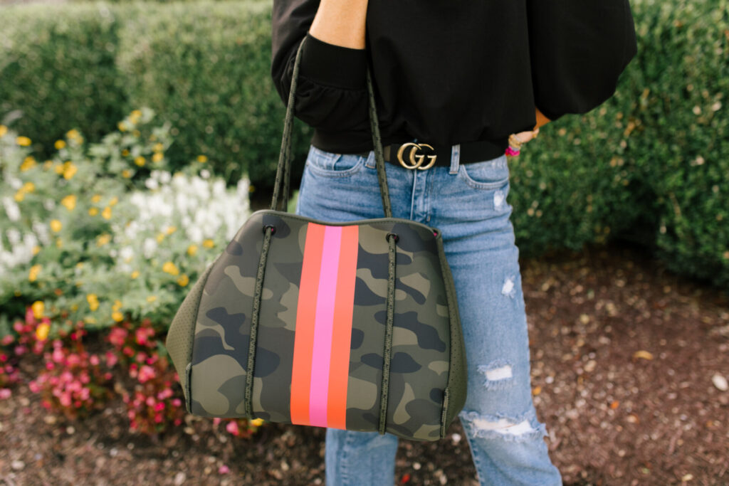 Social Threads by popular Nashville fashion blog, Hello Happiness: image of Natasha Stoneking standing outside and wearing a Amazon The Drop Women's Leona Short Puff Sleeve Crew Neck French Terry Sweatshirt, Social Threads Just Black Distressed Crop Kick Flare, Dillard's GB Here-4It Cheetah Print Haircalf Sneakers, and holding a Social Threads Hello Happiness Camo Striped Neoprene Tote.