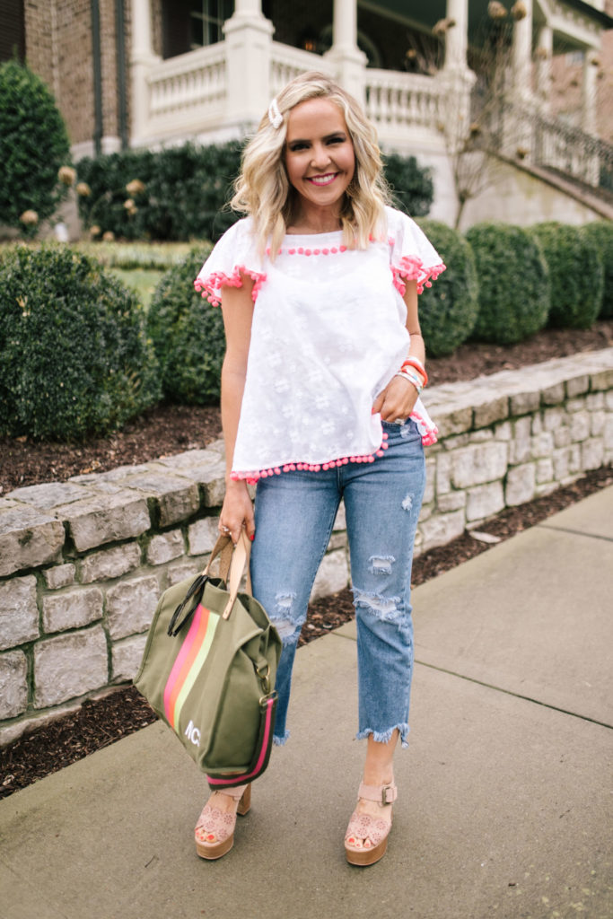 Sail to Sable by popular Nashville fashion blog, Hello Happiness: image of a woman wearing a Sail to Sable FLOUNCE SLEEVE POM POM TOP SKY, Social Threads Just Black Distressed Crop Kick Flare, Saks Fifth Avenue See by Chloé Krysty Floral Laser-Cut Suede Platform Sandals, Amazon pearl hair clip, and The Accessory Scout HAPPY DANCE EARRINGS.