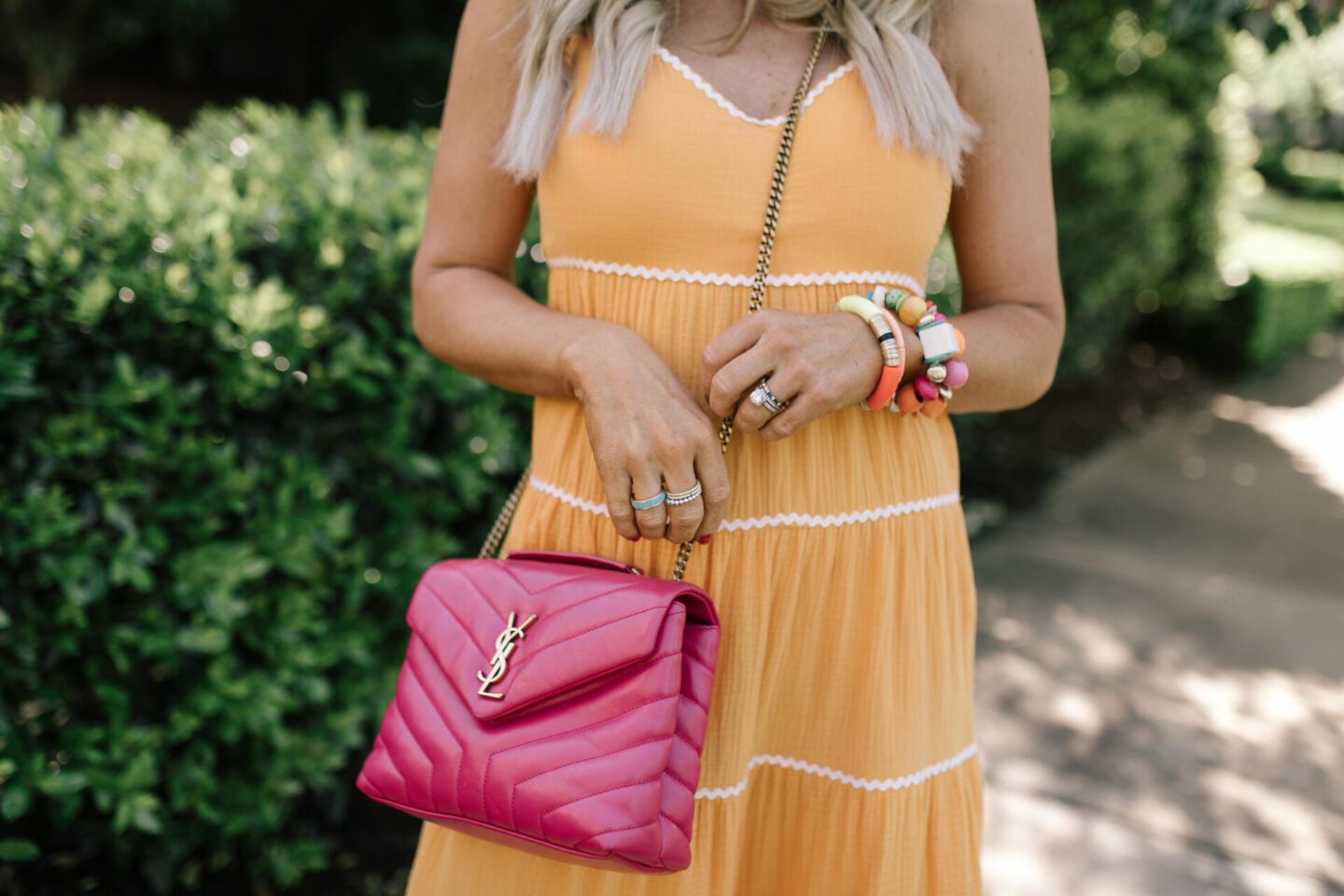 Scoop Dress by popular Nashville fashion blog, Hello Happiness: image of a woman wearing Scoop orange ric rac dress, multi color stretch bracelets, and a pink YSL bag. 