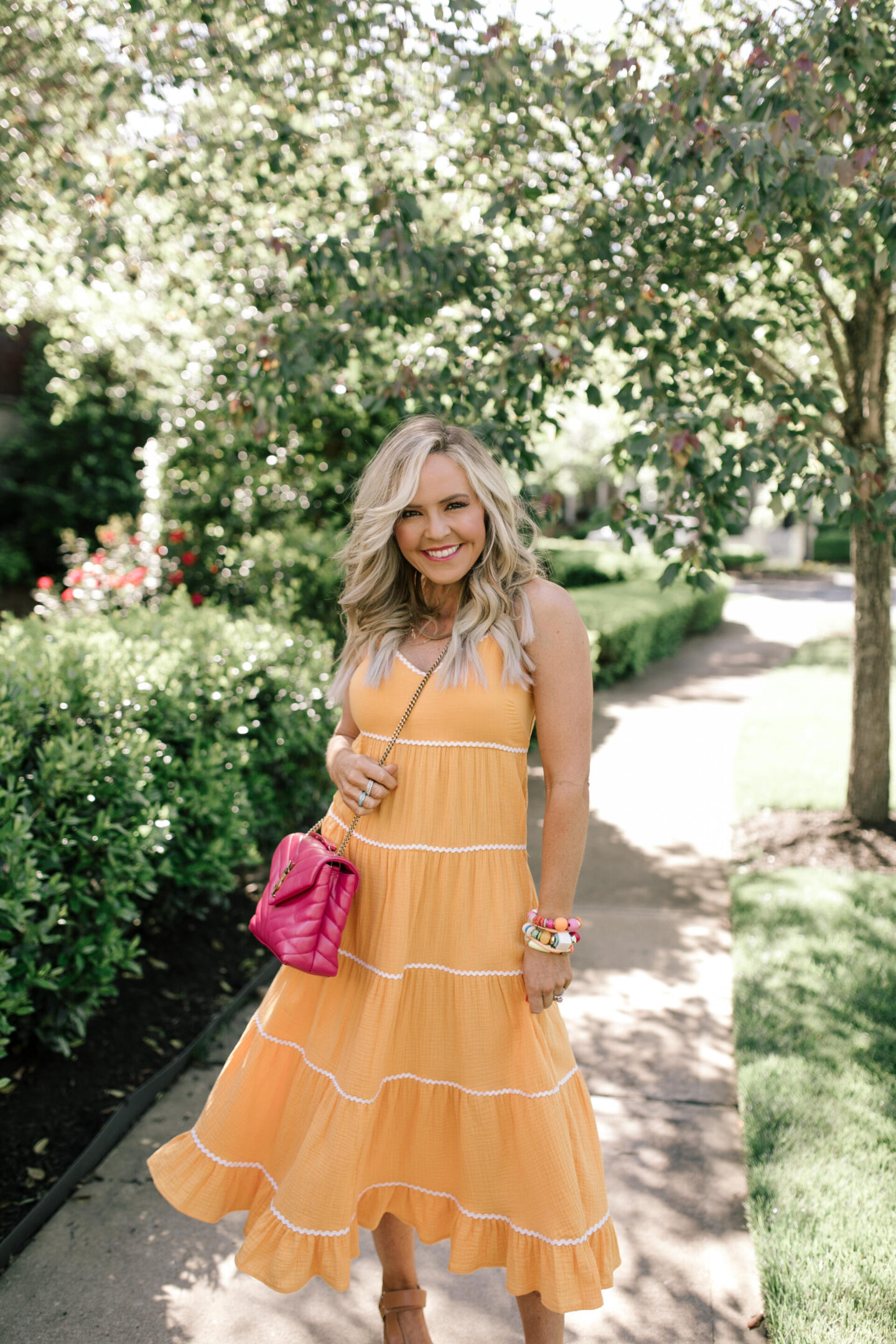 Scoop Dress by popular Nashville fashion blog, Hello Happiness: image of a woman wearing Scoop orange ric rac dress, multi color stretch bracelets, and a pink YSL bag. 