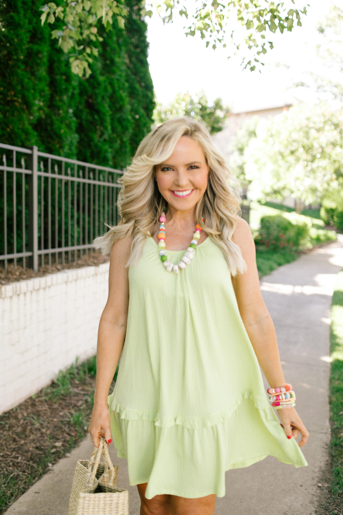 Scoop Dress by popular Nashville fashion blog, Hello Happiness: image of a woman wearing Scoop green cami rifle dress, multi color stretch bracelets, and holding a woven seagrass tote bag.