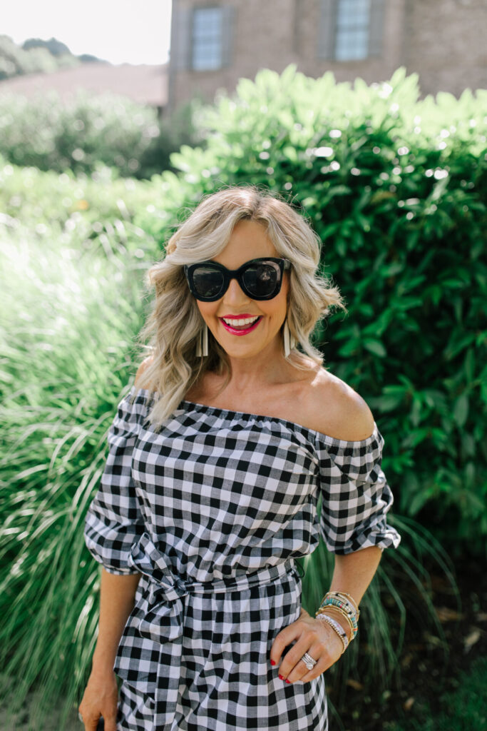 Gibson Look Road Trip by popular Nashville fashion blog, Hello Happiness: image of Natasha Stoneking wearing a Gibsonlook x Economy of Style Off the Shoulder Tie Waist Check Dress, Amazon Weekend Vibes Canvas Beach Bag, Amazon Freckles Mark Butterfly Sunglasses Semi Cat Eye Glasses, and MLDED Clay earrings.  