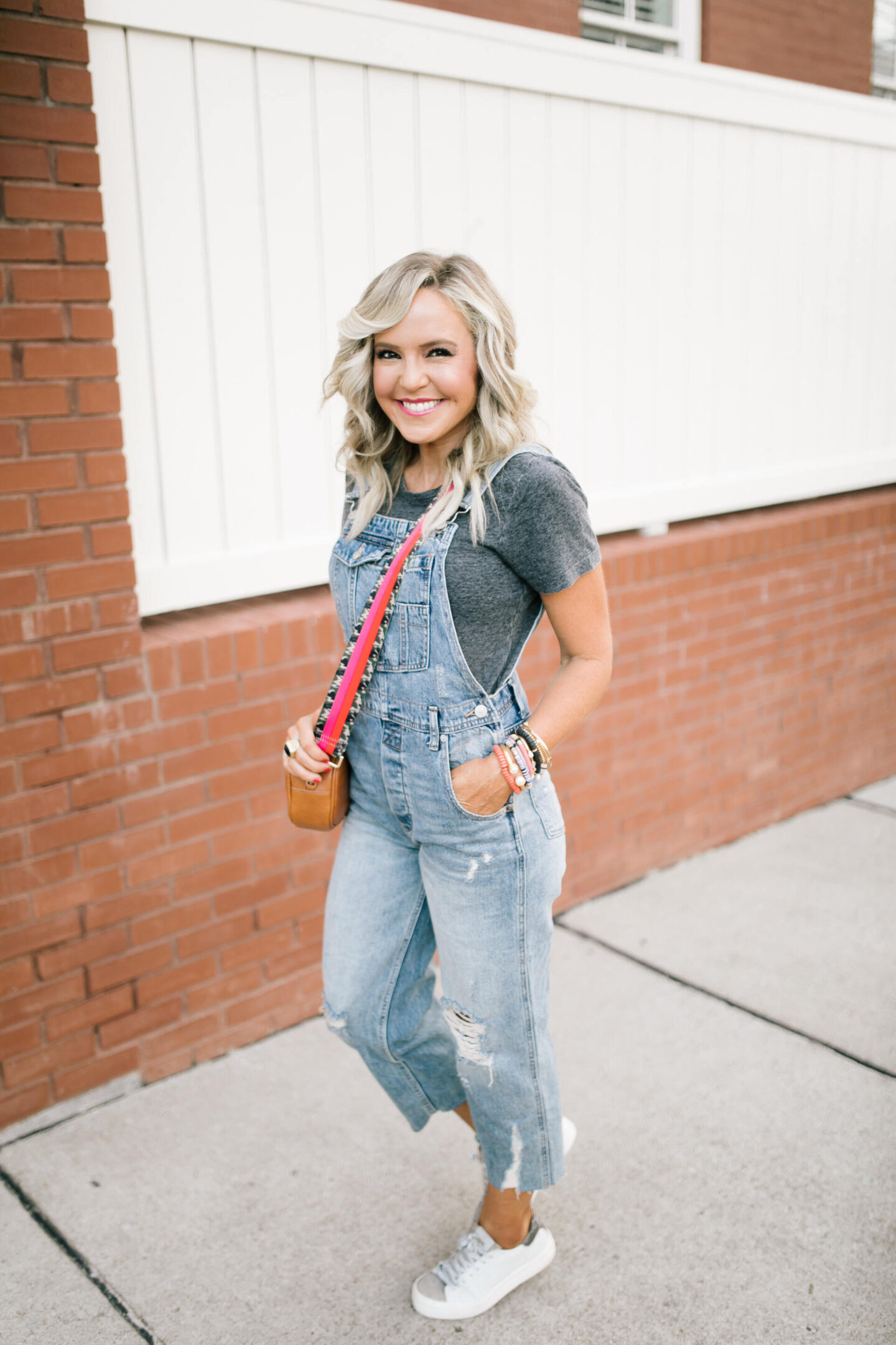Fancy Sneakers by popular Nashville fashion blog, Hello Happiness: image of Natasha Stoneking wearing boyfriend overalls, alchemy tee, and white and grey lace up sneakers. 