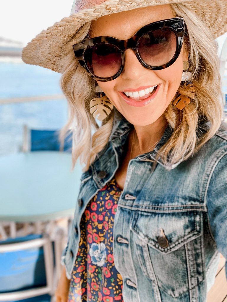 Disney Cruise Review... Set Sail with Mickey and Friends featured by top US travel blog, Hello! Happiness; image of woman wearing a straw hat, Monstera earrings, cropped denim jacket, sunglasses and a printed dress from Amazon