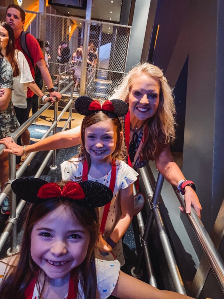 Disney Creators Celebration by popular Nashville lifestyle blog, Hello Happiness: image of two girls and their grandma standing in line for the Soarin' ride. 
