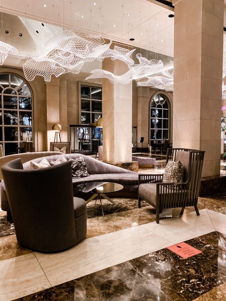 Hotel Crescent Court Dallas by popular Nashville travel blog, Hello Happiness: image of a hotel lounge area with modern furniture and ceiling art displays. 