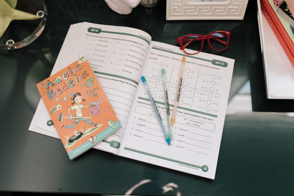 Walmart School Clothes by popular Nashville fashion blog, Hello Happiness: image of a workbook, gel pens, red frame glasses, and Amelia Bedelia Cleans Up book. 