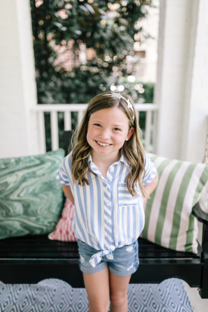 Walmart School Clothes by popular Nashville fashion blog, Hello Happiness: image of a young girl standing outside and wearing a pair of Walmart Celebrity Pink Girls 3" Mid-Ride Roll Cuff Shorts and a Walmart Wonder Nation Girls Tie-Front Shirt.
