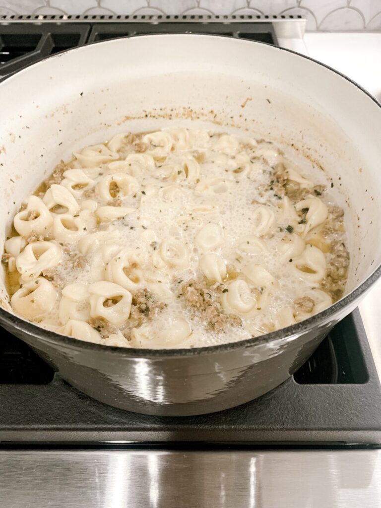 Tortellini Soup by popular Nashville lifestyle blog, Hello Happiness: image of tortellini soup in a Martha Stewart cast iron dutch oven. 
