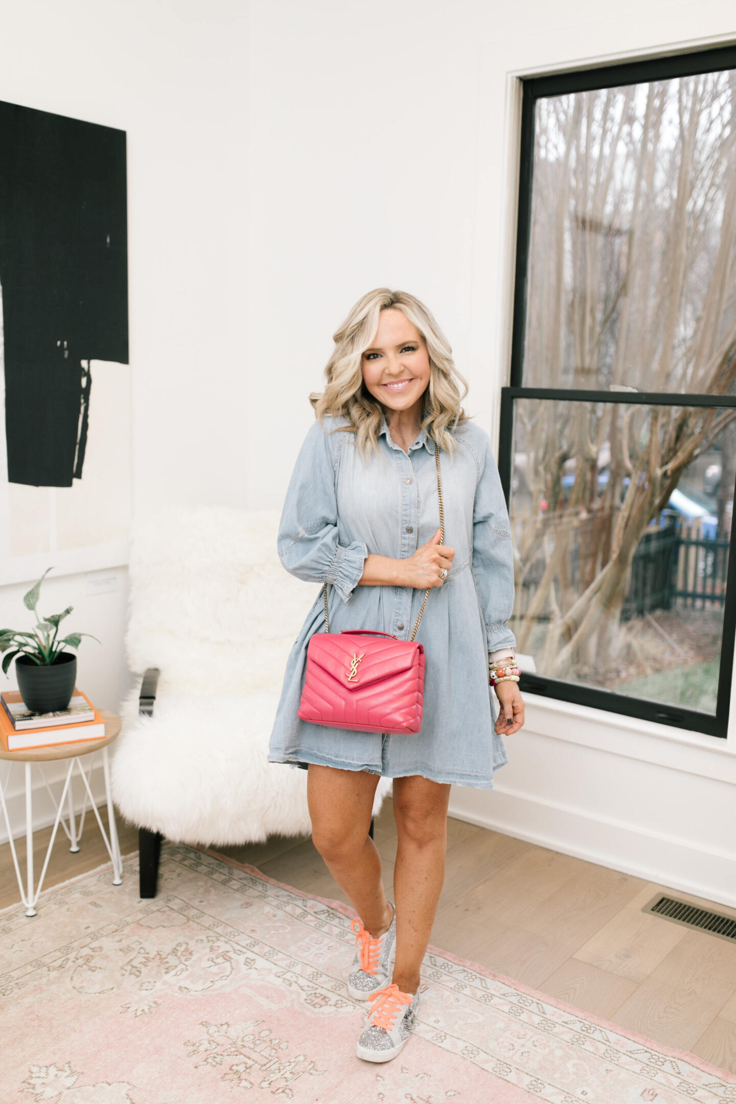 Denim Dresses by popular Nashville fashion blog, Hello Happiness: image of a woman wearing a Hannah mini denim dress, Zaga Glitter Sneakers, Ari Heart Ring, Natasha Beaded bracelet, Allie + Bess Zo Bracelets, and carrying a YSL pink small LouLou bag, 