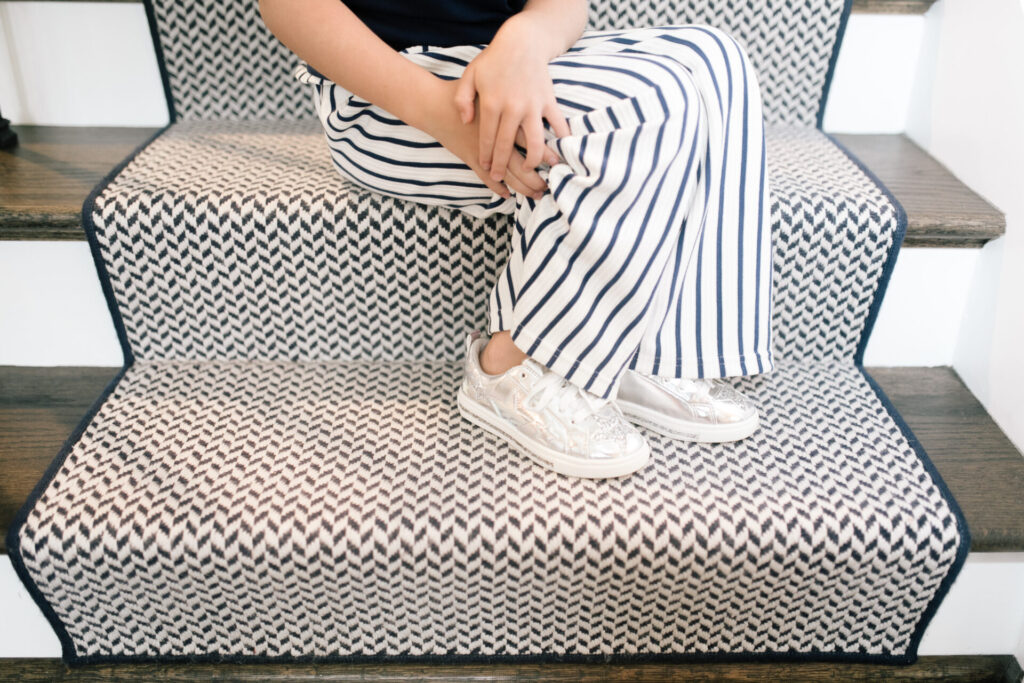 Walmart Back to School by popular Nashville life and style blog, Hello Happiness: image of a young girl sitting on a stair case and wearing a Walmart Jessica Simpson Girls Sleeveless Twist Front Top and Paper Bag Pants, Walmart Wonder Nation Shining Star Low-Top Court Sneaker.