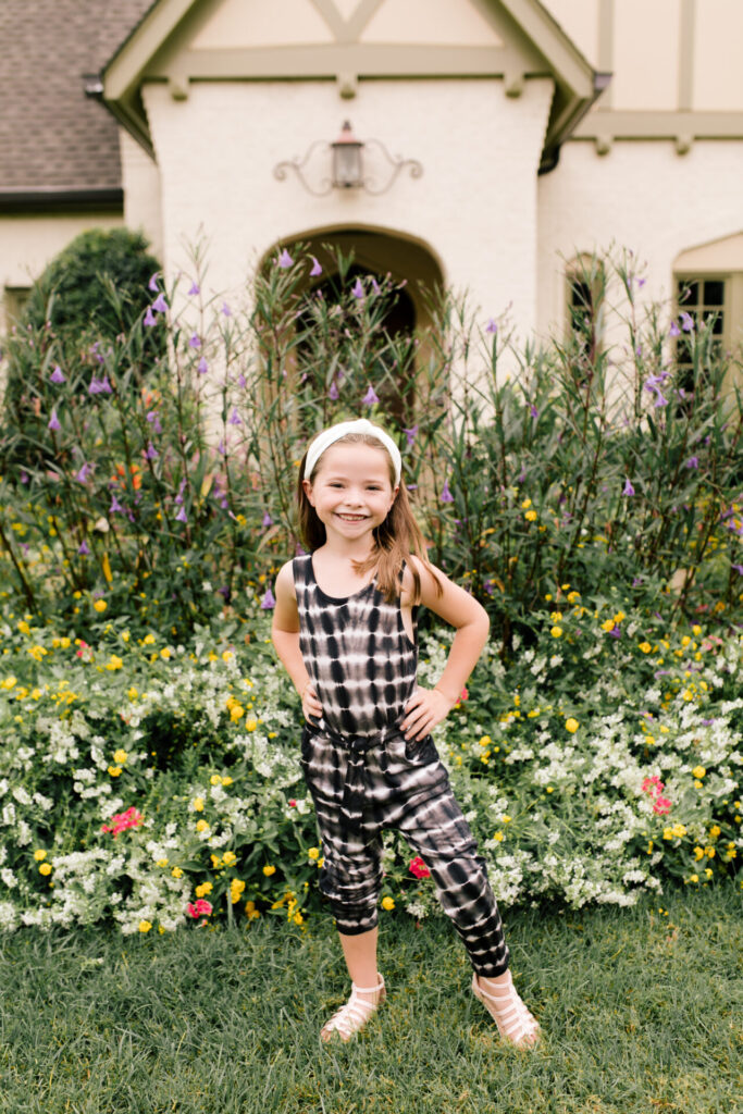 Tween Fashion by popular Nashville fashion blog, Hello Happiness: image of a girl standing outside and wearing a Target tie dye jumpsuit, gladiator sandals, and white knot headband.
