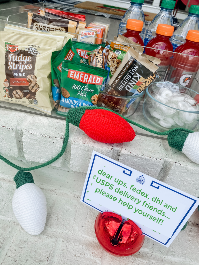 Walmart+ by popular Nashville lifestyle blog, Hello Happiness: image of a acrylic container filled with Emerald nuts, Kind bars, Fudge Stripe cookies, water bottles, and Snyder's pretzels. 