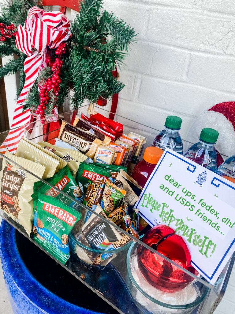Walmart+ by popular Nashville lifestyle blog, Hello Happiness: image of a acrylic container filled with Emerald nuts, Kind bars, Fudge Stripe cookies, water bottles, and Snyder's pretzels. 