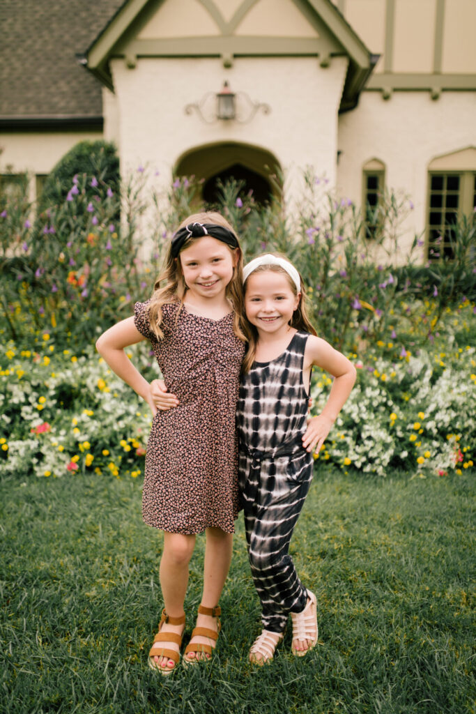 Tween Fashion by popular Nashville fashion blog, Hello Happiness: image of two girls standing together outside and wearing a Target tie dye jump suit, gladiator sandals, white knot headband, Target skater ditsy print swing dress, and brown espadrille sandals. 