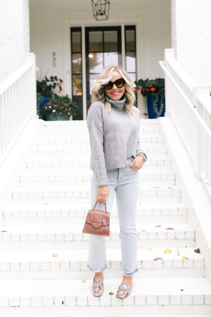 Fall Wardrobe by popular Nashville fashion blog, Hello Happiness: image of Natasha Stoneking standing on her front porch steps and wearing a Walmart Dreamers by Debut Women's Cowl Neck Sweater, Walmart Scoop Women’s Destructed Release Hem Crop Flare Jeans, Walmart Time and Tru Bit Loafer, and holding a Walmart Scoop Women's Faux Croco Top Handle Mini Crossbody Bag. 
