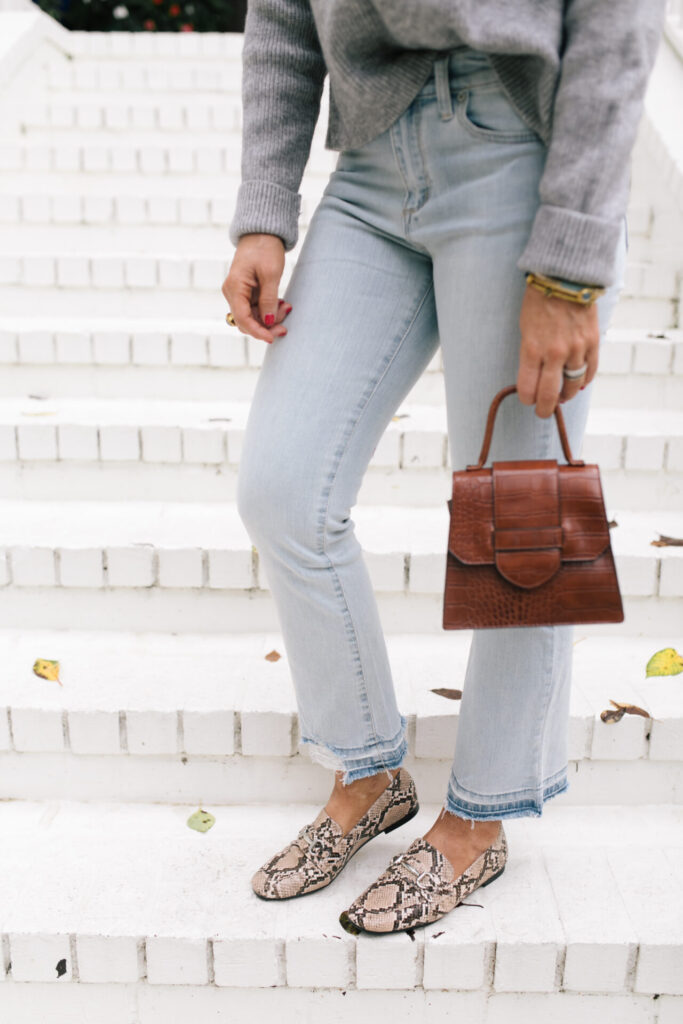 Fall Wardrobe by popular Nashville fashion blog, Hello Happiness: image of Natasha Stoneking standing on her front porch steps and wearing a Walmart Dreamers by Debut Women's Cowl Neck Sweater, Walmart Scoop Women’s Destructed Release Hem Crop Flare Jeans, Walmart Time and Tru Bit Loafer, and holding a Walmart Scoop Women's Faux Croco Top Handle Mini Crossbody Bag. 