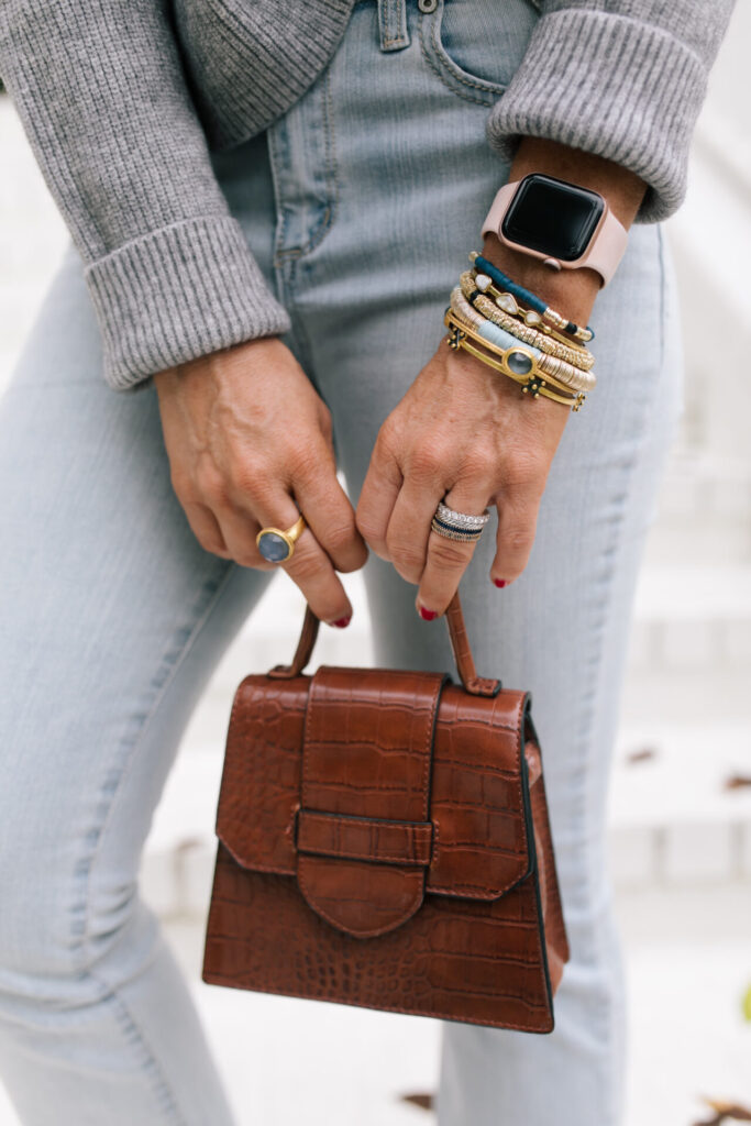 Fall Wardrobe by popular Nashville fashion blog, Hello Happiness: image of Natasha Stoneking standing on her front porch steps and wearing a Walmart Dreamers by Debut Women's Cowl Neck Sweater, Walmart Scoop Women’s Destructed Release Hem Crop Flare Jeans, Walmart Time and Tru Bit Loafer, and holding a Walmart Scoop Women's Faux Croco Top Handle Mini Crossbody Bag. 