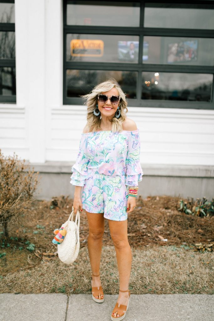 Hip Hip Hooray... The Lilly After Party Sale is Here! by popular Nashville fashion blog, Hello Happiness: image of a woman wearing a Lilly Pulitzer CALLA OFF-THE-SHOULDER ROMPER, STEVEN by Steve Madden Women's Sirena Espadrille Wedge Sandal, Amazon Straw Canteen Purse, Amazon I-BOSOM Colorful Boho Pom Pom Tassel Bag Charm Key Chain, and Nordstrom Quay Australiax JLO Limelight 54mm Oversize Sunglasses. 