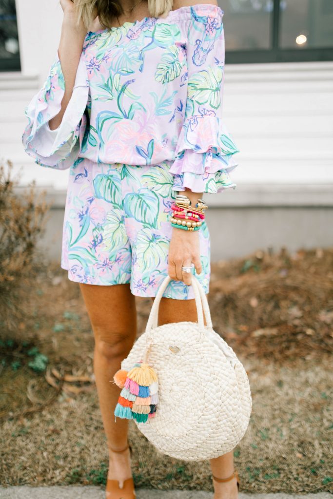 Hip Hip Hooray... The Lilly After Party Sale is Here! by popular Nashville fashion blog, Hello Happiness: image of a woman wearing a Lilly Pulitzer CALLA OFF-THE-SHOULDER ROMPER, STEVEN by Steve Madden Women's Sirena Espadrille Wedge Sandal, Amazon Straw Canteen Purse, Amazon I-BOSOM Colorful Boho Pom Pom Tassel Bag Charm Key Chain, and Nordstrom Quay Australiax JLO Limelight 54mm Oversize Sunglasses. 