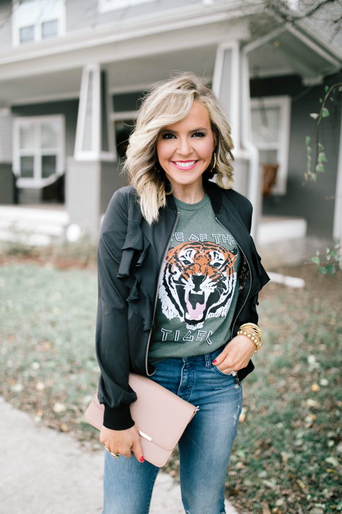 Say Hello to the Vici Collection in 2020! by popular Nashville fashion blog, Hello Happiness: image of a woman wearing a Vici POP CULTURE POCKETED RUFFLE BOMBER JACKET, Vici COTTON BLEND EYE OF THE TIGER TEE, Vici KARLA HIGH RISE CROP FLARE DENIM, and Vici HERMIONE FAUX LEATHER CROSSBODY BAG.