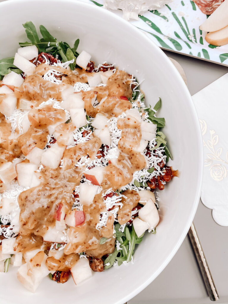 Goat Cheese Salad by popular Nashville lifestyle blog, Hello Happiness: image of a apple, arugula, candid pecan, and goat cheese salad in a Pottery Barn Emma Beaded Serving Bowl next to a Anthropologie Streamlined Serving Set.