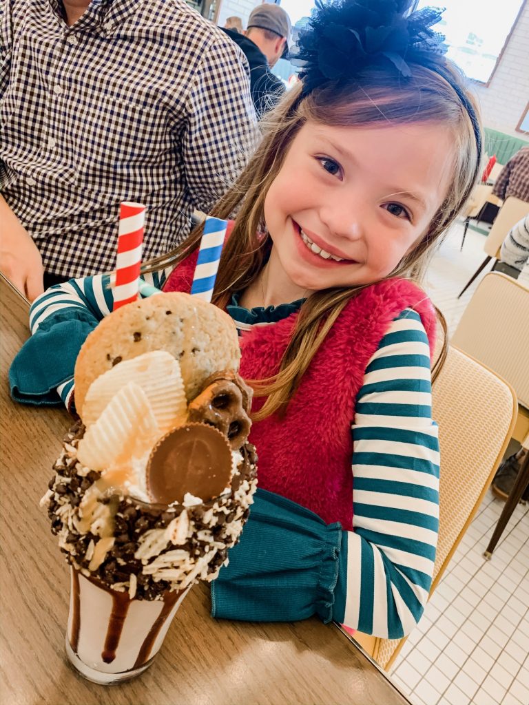 Meet Me for a Weekend in St. Louis | The Perfect Family Getaway by popular travel blog, Hello Happiness: image of a girl with an ice cream sundae at the Soda Fountain. 
