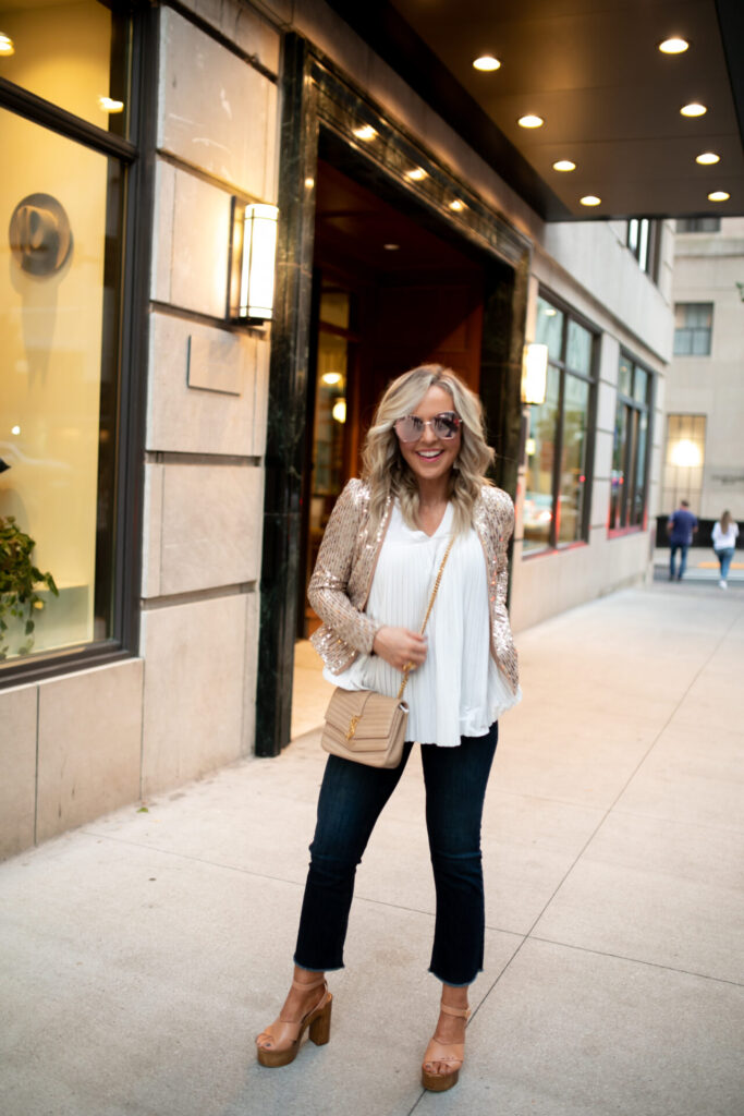 Fake Tan by popular Nashville beauty blog, Hello Happiness: image of a woman in downtown Nashville wearing a Molly Bracken SEQUINED BLAZER, Molly Bracken pleated top, MLDED Clay earrings, and Quay Australia Big Love sunglasses. 