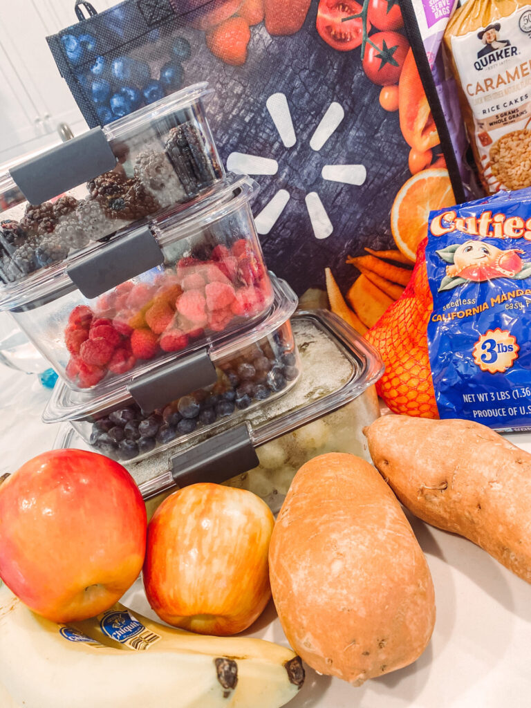 Walmart Membership by popular Nashville lifestyle blog, Hello Happiness: image of berries and grapes in glass storage containers next to some apples, bananas, sweet potatoes, and reusable Walmart shopping bags. 