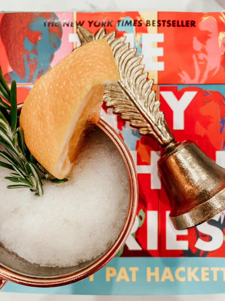 Summer Cocktail by popular Nashville lifestyle blog, Hello Happiness: image of a grapefruit whiskey slush in a Target Old Dutch Copper Hammered Moscow Mule Mug on top of The Andy Warhol Diaries and kate spade new york: places to go, people to see.