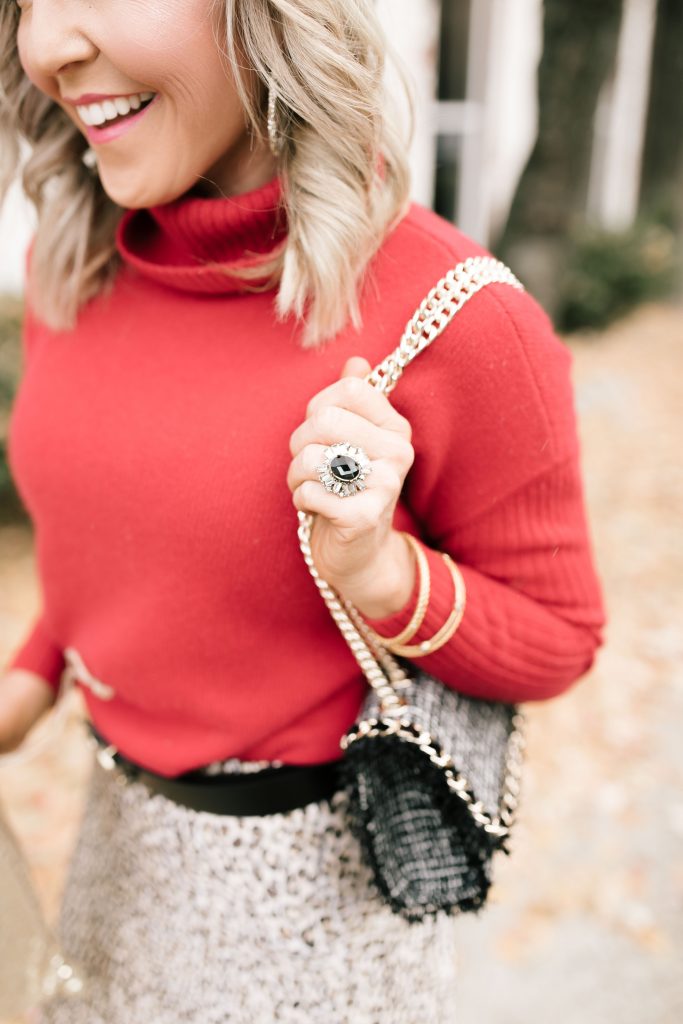 Cheers to Chicos RED by popular Nashville fashion blog, Hello Happiness: image of a woman outside wearing a Chicos red CASHMERE TURTLENECK, Chicos LEOPARD-PRINT MAXI SKIRT, Chicos SIMULATED STONE RING, and carrying a Chicos CONVERTIBLE TWEED SHOULDER BAG.