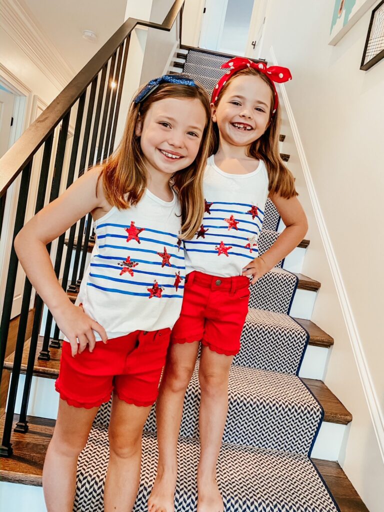 Year in Review by popular Nashville lifestyle blog, Hello Happiness: image of two young girls standing together on a set of stairs and wearing matching 4th of July outfits. 