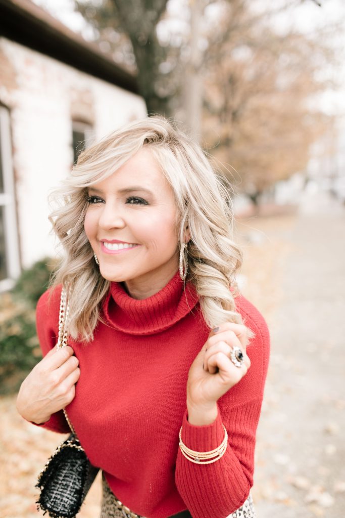 Cheers to Chicos RED by popular Nashville fashion blog, Hello Happiness: image of a woman outside wearing a Chicos red CASHMERE TURTLENECK, Chicos LEOPARD-PRINT MAXI SKIRT, Chicos SIMULATED STONE RING, and carrying a Chicos CONVERTIBLE TWEED SHOULDER BAG.