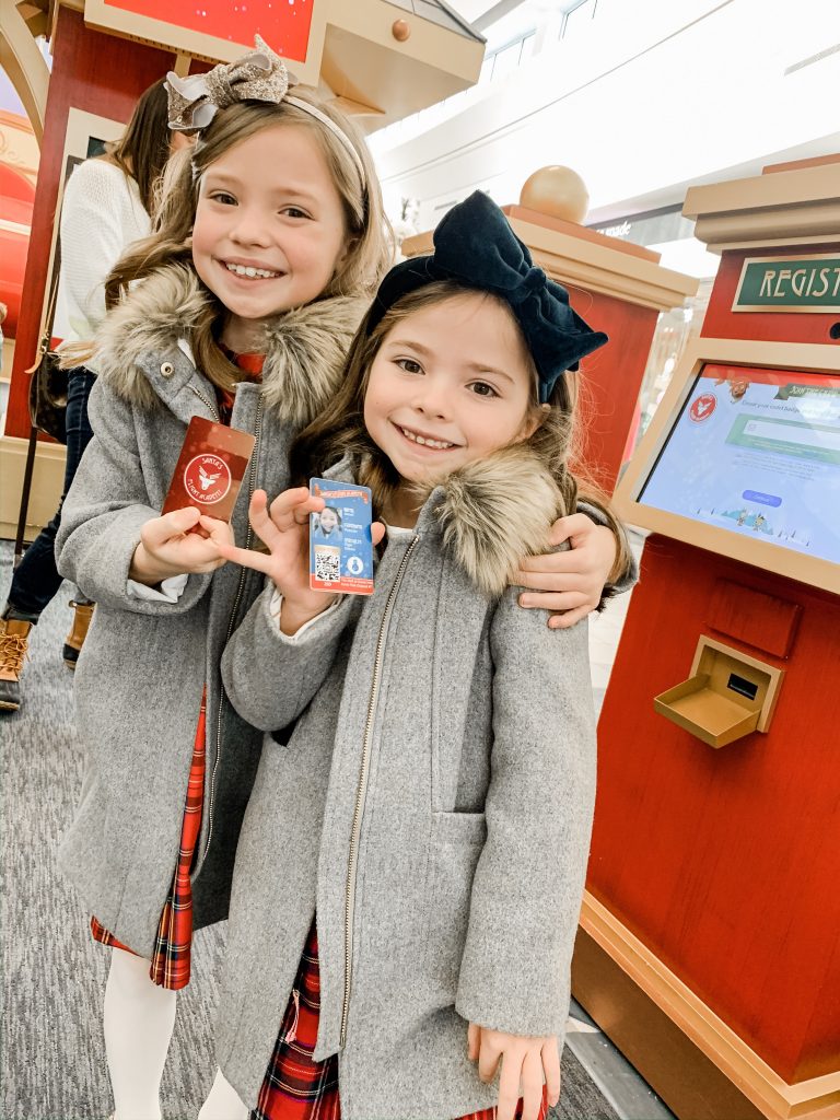 All Our Favorite Family Holiday Traditions by popular life and style blog, Hello Happiness: image of two girls at Santa's flight academy and wearing J. Crew Girls' chateau parkas.