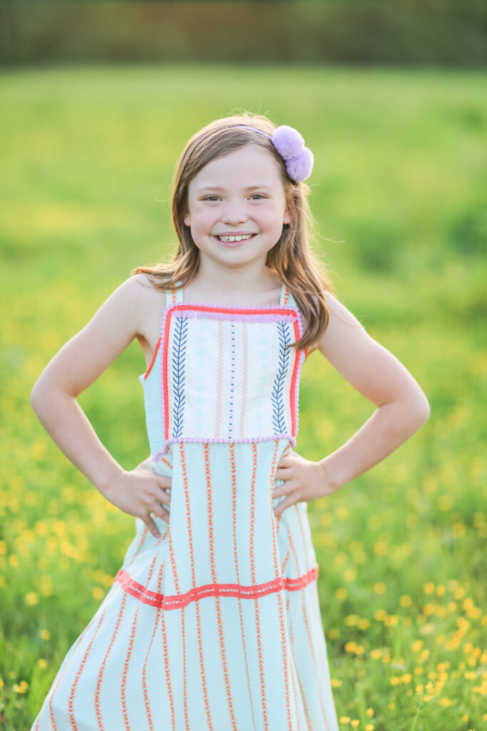 Summer Bucket List by popular Nashville lifestyle blog, Hello Happiness: image of a girl standing in a grassy meadow and wearing Matilda Jane Clothing dresses. 