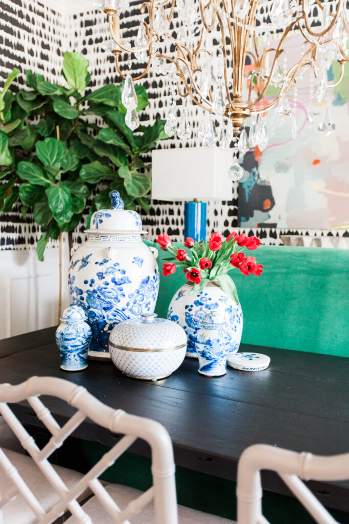 Ginger Jars by popular Nashville life and style blog, Hello Happiness: image of a black table with white chairs decorated with ginger jars and red tulips. 